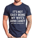 Funny Husband 'S Not Easy Being My Wife Arm Candy Husband Shirt Husband Joke Short Sleeve Top T-Shirts, Hoodie, Sweatshirt - T-Shirt, Sweatshirt, Hoodie