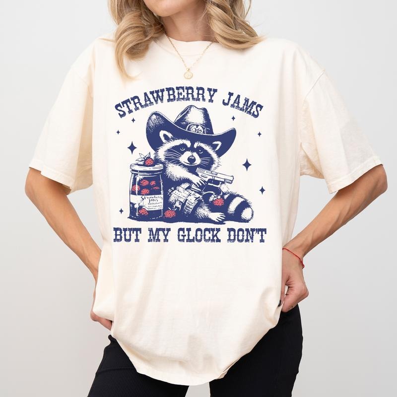 Strawberry Jams But My Glock Don'T Comfort Colors Shirt Western Cowboy Raccoon Funny Meme Raccoon Lovers Womenswear T-Shirts, Hoodie, Sweatshirt - T-Shirt, Sweatshirt, Hoodie