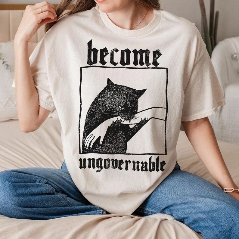 Become Ungovernable Cat Meme Shirt Biting Hand Funny Rebel Graphic Tee Unisex T-shirt, Sweatshirt, Hoodie, Long Sleeve Tee - T-Shirt, Sweatshirt, Hoodie